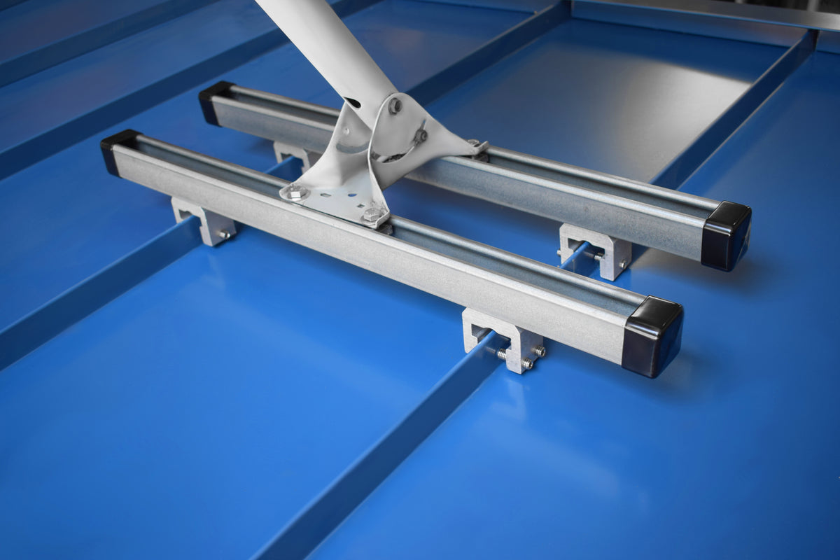 Actual SataMount RCT installation clamped to a blue standing seam metal roof, supporting two mounting rails and a satellite mounting bracket