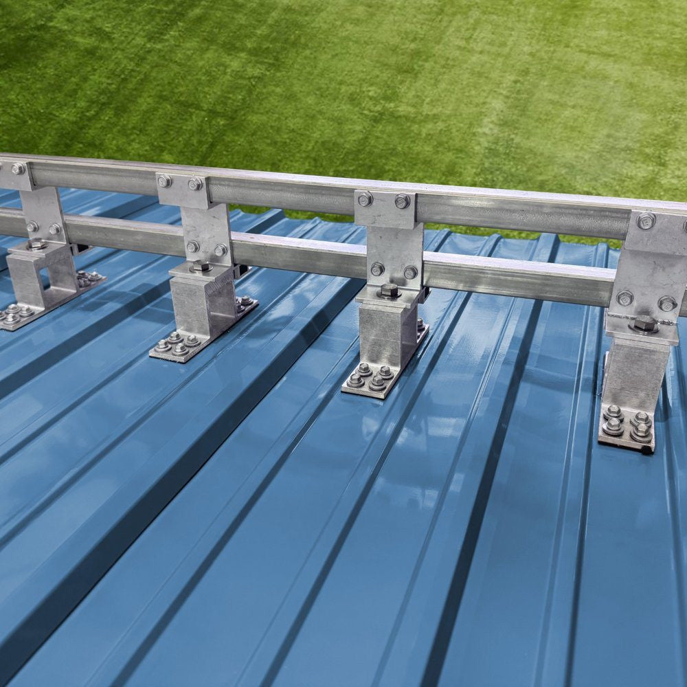 Screw-down SnoBar double bar snow retention system mounted on metal roofing panel close-up