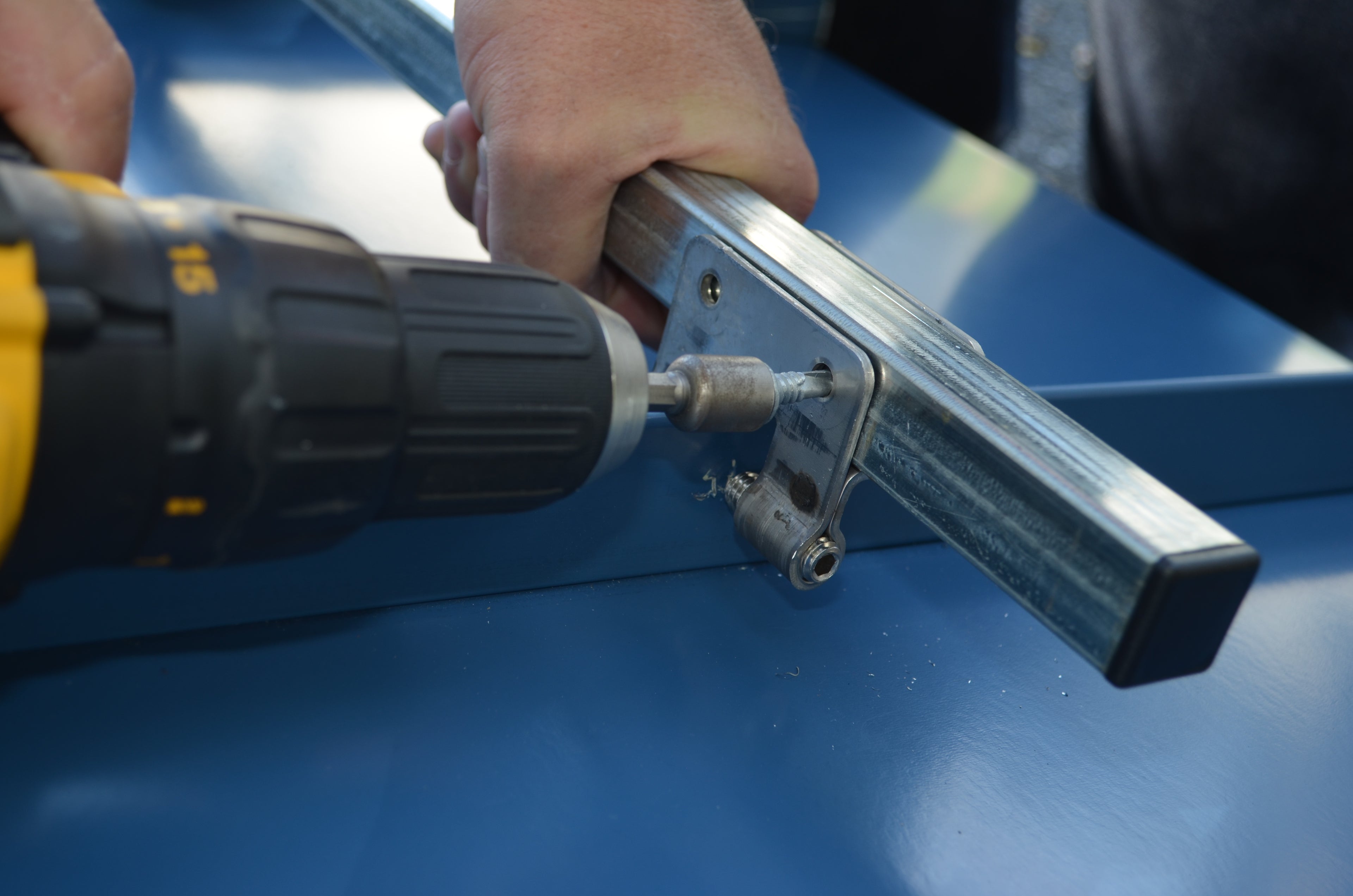Installing a SnoBar snow rail on a standing seam metal roof using clamp-mounted attachment.